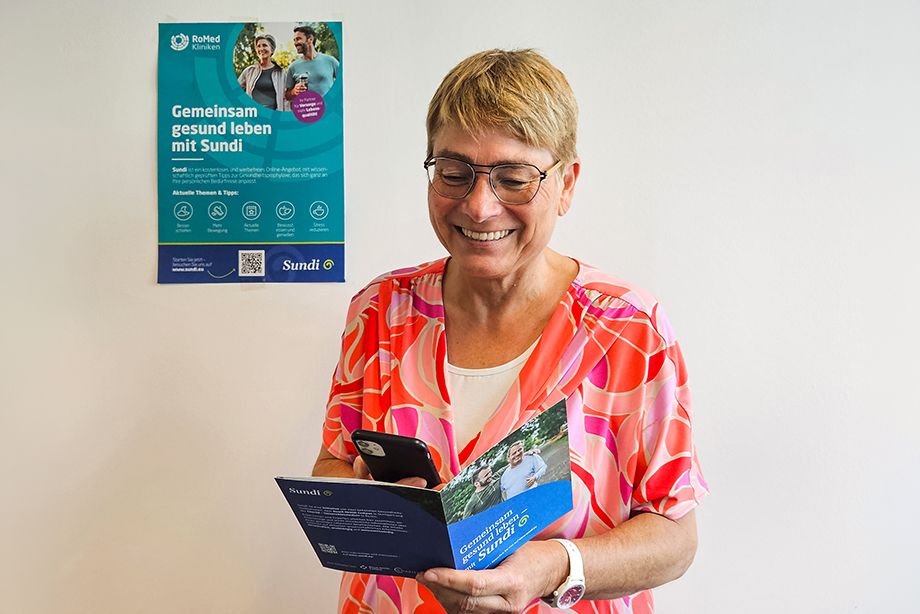 Einfacher Zugang zur Gesundheitsvorsorge: Judith Hantl-Merget, RoMed-Pflegedirektorin und Prokuristin zeigt, wie Interessierte über den Flyer und den QR-Code direkt zum digitalen Präventionsangebot Sundi gelangen. 