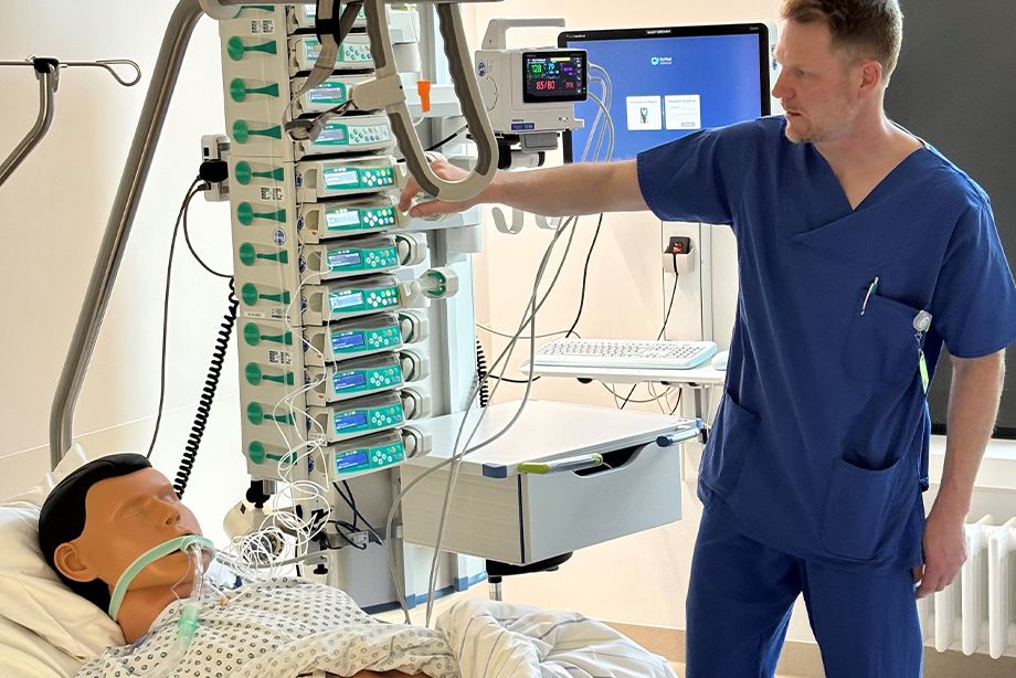 Im Intensivzimmer erläutert der Stationsleiter an einer Pflegepuppe die Beatmungstherapie und Dialyse.